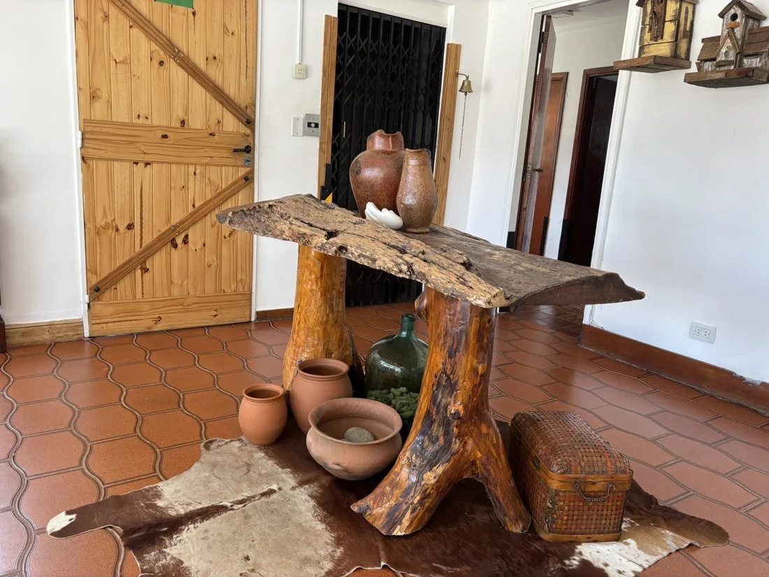 Detalle del recibidor de Fountain of Life, con mobiliario de madera y objetos de cerámica